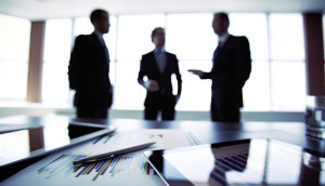 Blurred business meeting with charts and graphs on a table.