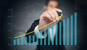 Businessman drawing a rising graph with a yellow marker, symbolizing growth or progress.