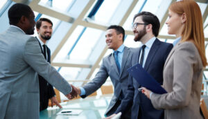 Business professionals shaking hands in a corporate setting.