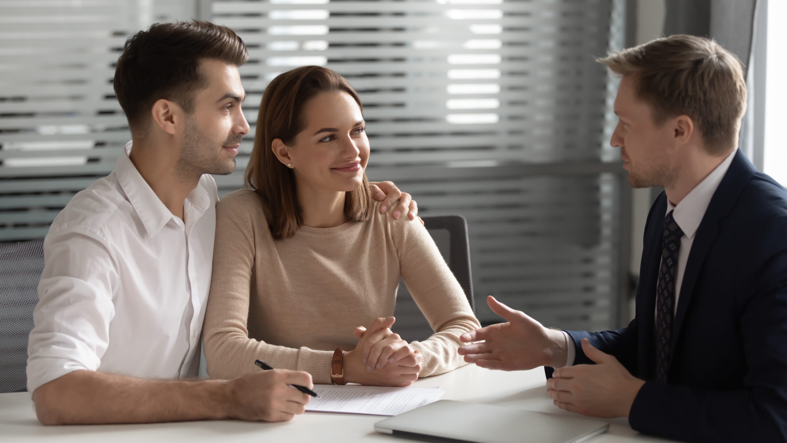 A couple sitting at a desk, talking with a business professional.