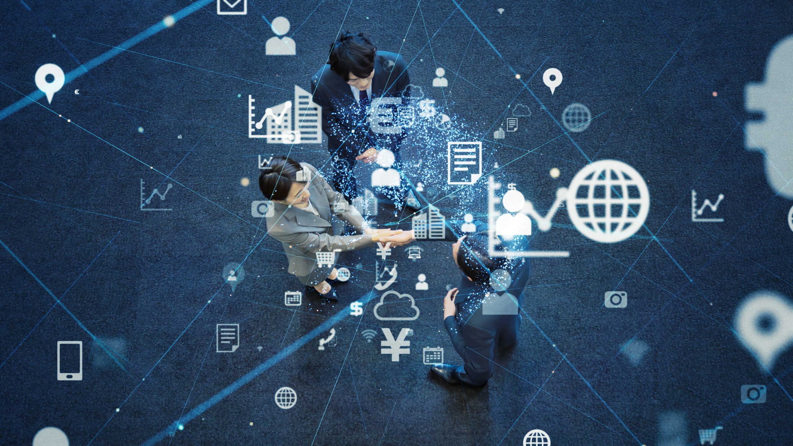 Overhead view of businesspeople shaking hands, surrounded by digital icons representing data and networking.