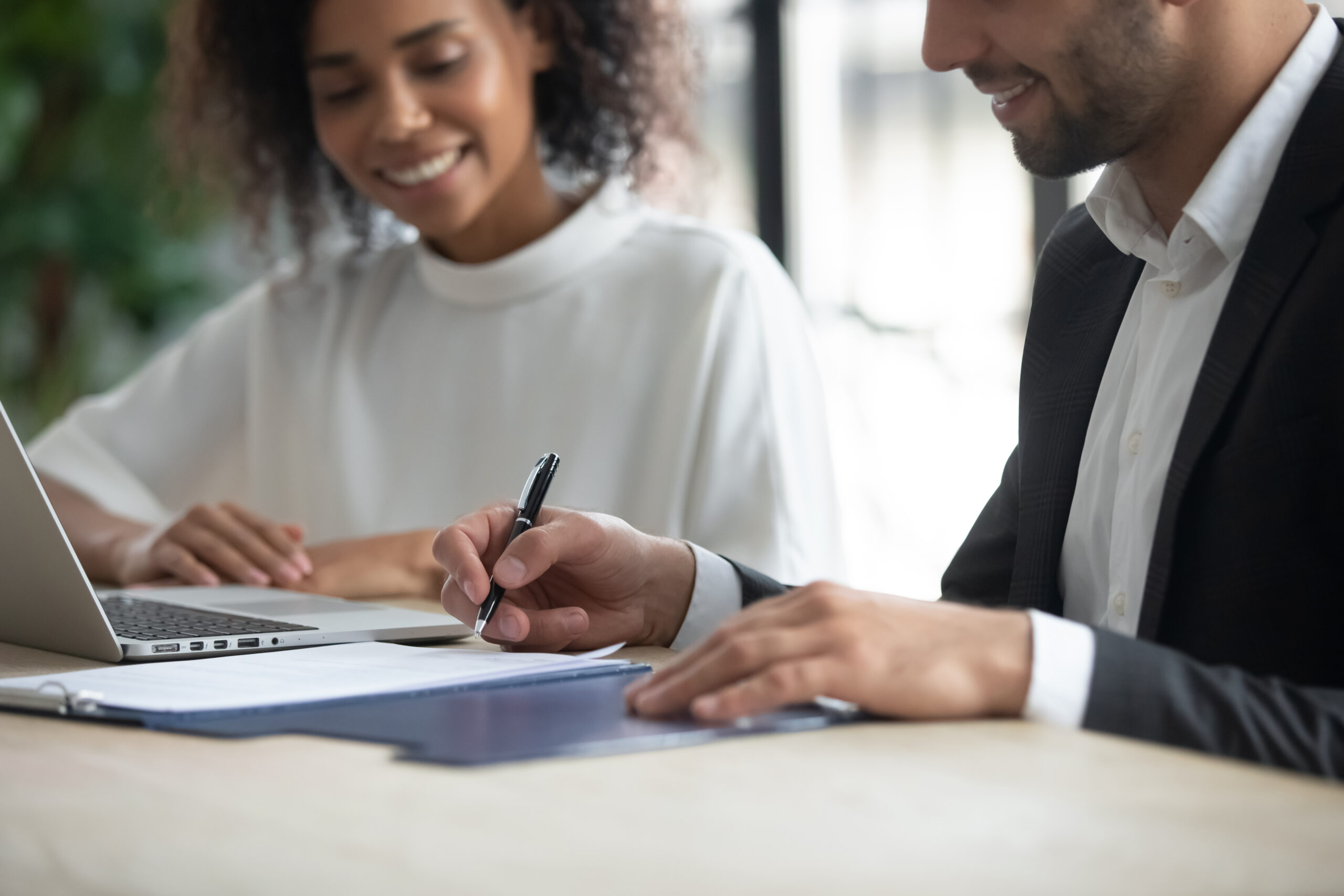 Two businesspeople reviewing and signing documents together.