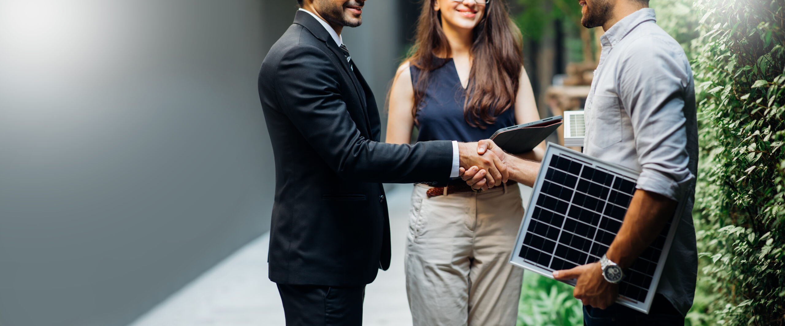 Business handshake in a green energy setting, symbolizing sustainable partnerships.